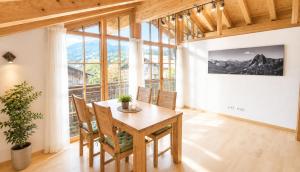 a dining room with a table and chairs and a large window at AlpStern Ferienwohnungen Oberstdorf in Oberstdorf
