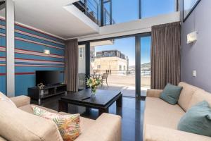 a living room with two couches and a table at Skyline Living, Table Mountain Views in Cape Town