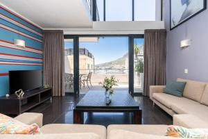 a living room with a couch and a tv at Skyline Living, Table Mountain Views in Cape Town