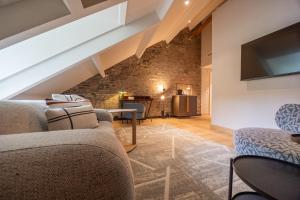 a living room with a couch and a tv at Hotel Maison Maastricht Centrum - Handwritten Collection in Maastricht