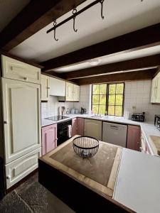 a kitchen with pink cabinets and a counter top at Bay View Ridge Cottage in Bantry