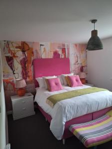 a bedroom with a large bed with pink accents at Number Three Wadebridge in Wadebridge +10 photos