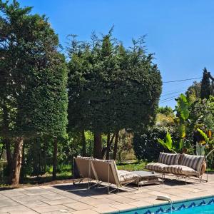 a group of chairs sitting next to a swimming pool at Villa Marguerite in Hyères