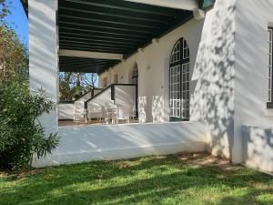 a white house with a porch with chairs at Charmant Appartement - Bordaberry in Urrugne