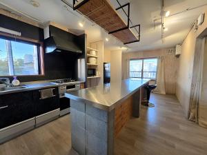 a large kitchen with a large island in the middle at Snow Nest Lodge in Sapporo