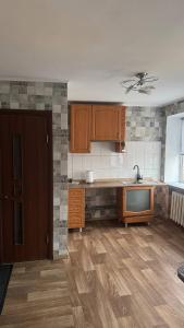 a kitchen with wooden cabinets and a tv in it at Хостел in Sumy