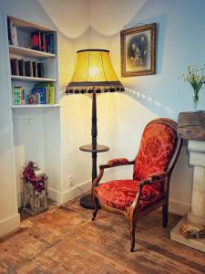 a lamp and a chair in a room at Chez Kapameï in La Clayette