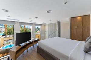 a bedroom with a large bed and a flat screen tv at Sataya Resort Marsa Alam in Marsa Alam City