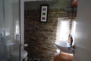 a bathroom with a sink and a toilet and a brick wall at Rockfield House in Kells +60 photos