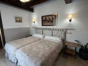 a bedroom with a large bed with white sheets at Amaicha Casona in Ribadesella