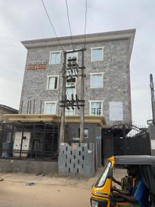 a person riding a scooter in front of a building at Hymax Grace hotel in Bolorunpelu