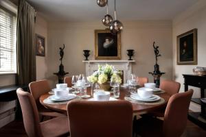 a dining room with a wooden table and chairs at The Gatehouse in Peterborough