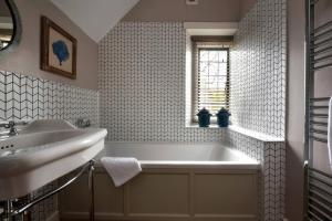 a bathroom with a white tub and a sink at The Gatehouse in Peterborough +29 photos