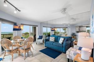 a living room with a blue couch and a table and chairs at Gulf Strand Resort by Travel Resort Services in St. Pete Beach