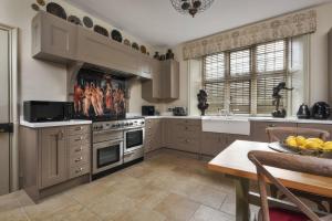 a kitchen with white cabinets and a table with a bowl of fruit at Morland Manor in Peterborough