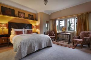 a bedroom with a bed and a desk and chairs at Morland Manor in Peterborough