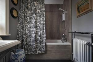 a bathroom with a shower curtain and a bath tub at Morland Manor in Peterborough +25 photos