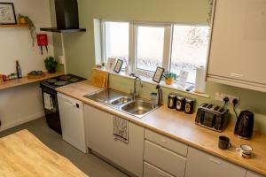 a kitchen with a sink and a stove at Railway Sleeper Hostel in Castlerock