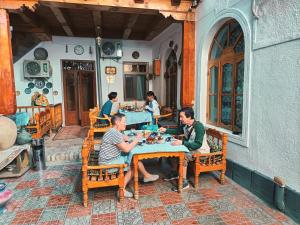 a group of people sitting at a table in a restaurant at Hotel Nazira & Azizbek in Bukhara