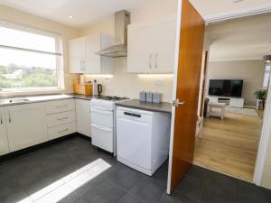 a kitchen with white cabinets and a stove top oven at Trem Y Foel in Penrhyndeudreath