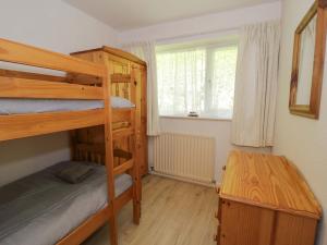 a bedroom with two bunk beds and a table at Trem Y Foel in Penrhyndeudreath