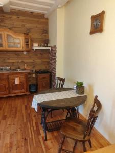 a kitchen with a table and chairs and a clock on the wall at STĀRĶA APARTAMENTI in Kuldīga