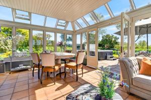 a conservatory with a table and chairs and a couch at 5 Bed in Hereford oc-83658 in Madley