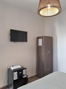 a bedroom with a bed and a tv on the wall at CASABLANCA CATAMARCA Guest House in San Fernando del Valle de Catamarca