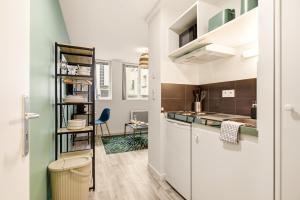 a kitchen with white cabinets and a counter at Studio L'Émeraude - F1 lumineux, hypercentre - CAEN in Caen