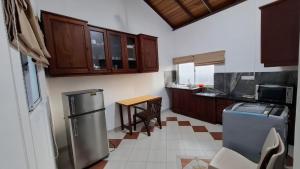 a kitchen with a stainless steel refrigerator and a table at Joyous Cottage in Maharagama