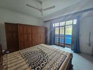 a bedroom with a large bed and a window at Joyous Cottage in Maharagama