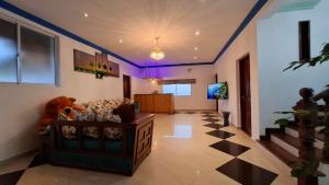 a living room with a couch and a tv at Joyous Cottage in Maharagama
