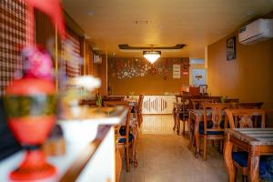 a restaurant with wooden tables and chairs in a room at The R One in Male City +35 photos