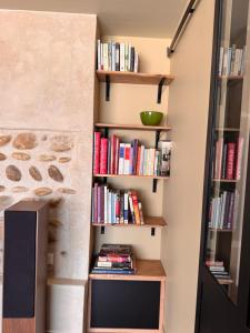 a book shelf in a hallway with books at La Grange Guesthouse in Beausemblant