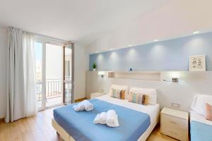 a bedroom with two beds and a large window at Hotel Perla Gaia in San Vito lo Capo
