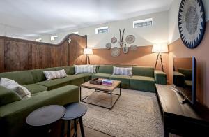 a living room with a green couch and a table at The Lady Rothschild Stables in Peterborough