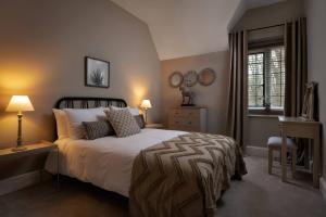 a bedroom with a bed and a desk and a window at The Lady Rothschild Stables in Peterborough