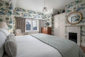 a bedroom with a large white bed and a fireplace at Greenwood Manor in Peterborough