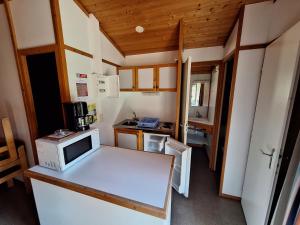 a small kitchen with a microwave on a counter at Camping Verte Rive in Saint-Laurent-de-Cerdans