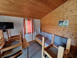 a room with a couch and a table and a tv at Camping Verte Rive in Saint-Laurent-de-Cerdans