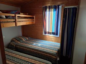 a small bedroom with a bunk bed and a window at Camping Verte Rive in Saint-Laurent-de-Cerdans