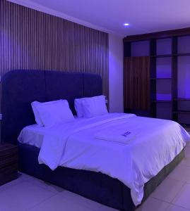 a bedroom with a large bed with white sheets at Kris Courts in Ibadan
