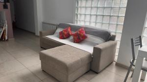 a couch with two pillows on it in a living room at Duplex Jardines del Rey in Neuquén