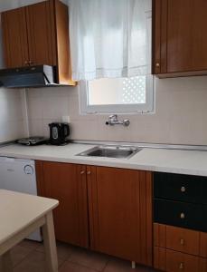 a kitchen with a sink and a window at Achilleas Apartments in Paralía Skotínis +34 photos