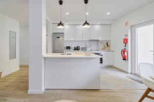 a kitchen with white cabinets and a white counter top at Fonte Nova Nest, By Home Match in Setúbal