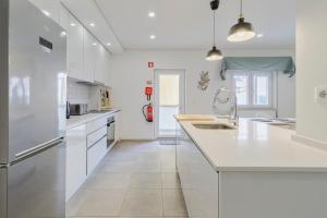 a kitchen with white cabinets and a large white counter top at Fonte Nova Nest, By Home Match in Setúbal