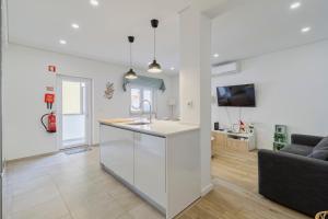 a kitchen and living room with a sink and a couch at Fonte Nova Nest, By Home Match in Setúbal