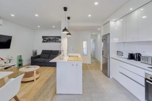 a white kitchen and living room with a couch at Fonte Nova Nest, By Home Match in Setúbal +17 photos