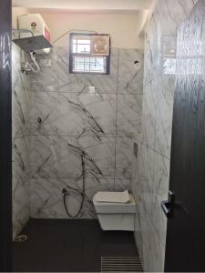 a bathroom with a shower and a toilet in it at Hotel Comfort Inn in Rānchī