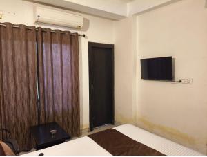 a bedroom with a bed and a television on the wall at Hotel Comfort Inn in Rānchī